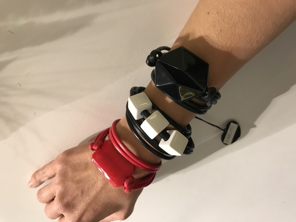 Tris di bracciali da girare attorno al polso: Bracciale con elemento plexi medio 11) Rosso, Bracciale cubetti 01) Nero e Bracciale con elemento plexi grande 01) Nero