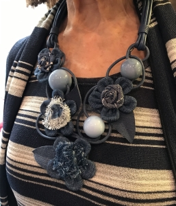 Dettaglio della meravigliosa collana indossata da Cilla. Una vera scultura interamente modellata e cucita a mano con fine lavorazione artigianale. Fiori e sfere si mixano per un effetto femminile e molto glamour.