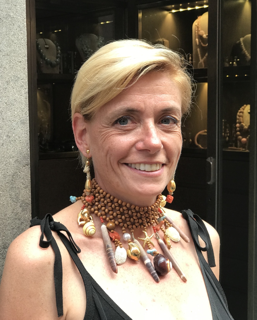 Bellissima la nostra Sabri con questo collier de chain realizzato interamente a mano con una maglia di sfere in legno e tanti pendenti a tema marino: conchiglie naturali, cassetti in corallo e turchese, elementi in plexiglas metallizzato.