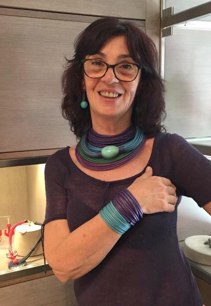 Splendide sfumature di colore che ricordano i fondali marini per queste creazioni indossate da Sandra: Collier de chain, collana a fili sfumata e girocollo tubolare con elemento in turchese, sono tre bijoux iconici di Cillabijoux, qui portati insieme per un effetto super scenografico ma bellissimi anche singolarmente. Orecchini con boulle in plexiglas e cappiolina in filato, bracciali a fascia in filato.