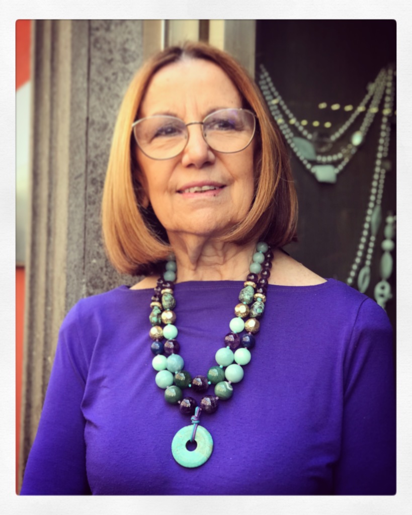 Cilla indossa due collane realizzate con splendide pietre dure nei toni del turchese, viola e verde smeraldo. Sono pezzi unici di Cillabijoux