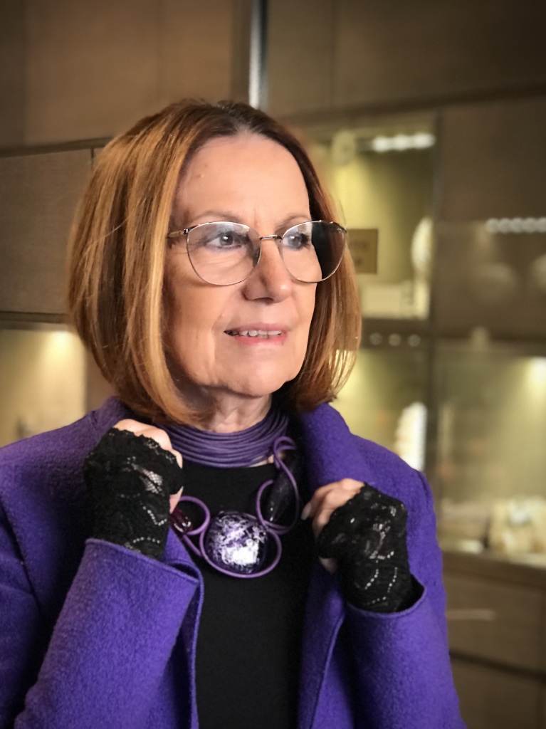 Cilla  indossa un collier de chain a fascia in filato di cotone cerato viola e una collana fantasia, interamente modellata a mano, con filato in cotone cerato e maxi elementi in plexiglas.