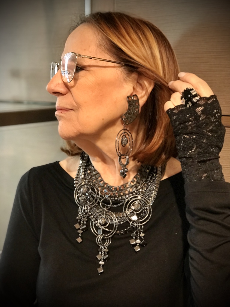 Dettaglio della collana indossata da Cilla: da notare la straordinaria luminosità delle catene metalliche brunite ed i grandi ciondoli con elementi in Ematite naturale e sfere con Cristalli Swarovski fumè. Di grande effetto e dall'anima rock, è un gioiello originale e sofisticato. E' un pezzo unico realizzato per l'Alta moda.