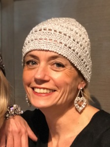 Sabrina indossa indossa un cappellino calotta in lurex platino ed orecchini a forma di cuore con cristalli Swarovski 
