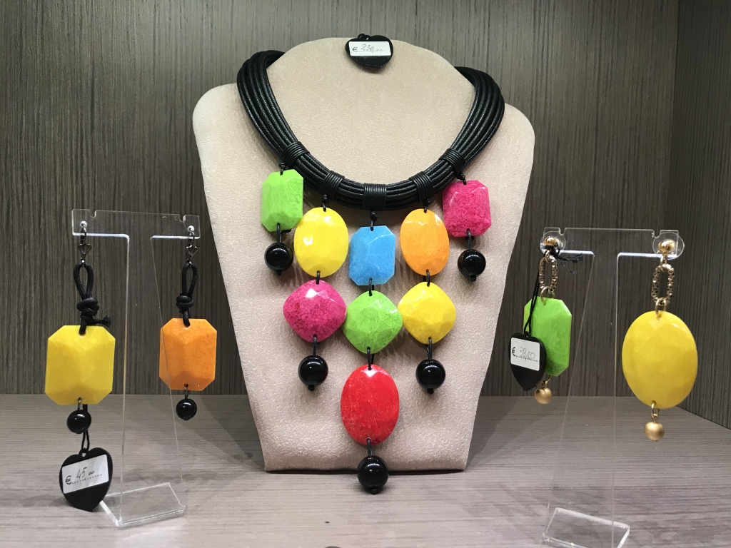 Una delle nostre vetrine "Colorful Shapes", al centro una collana multicolor realizzata con filato in cotone cerato nero e tanti elementi colorati in plexiglas, abbinati "Orecchini colorful shapes" sia nella versione base nero che base oro.