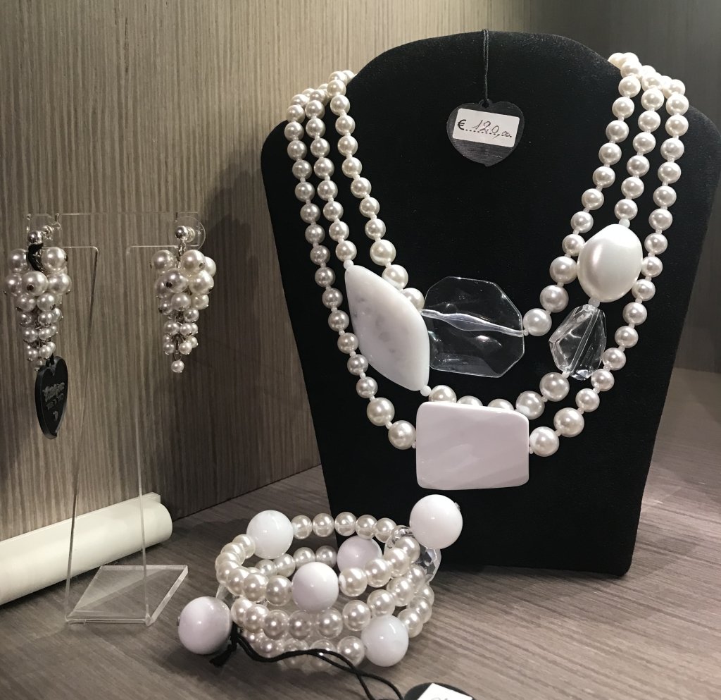 "Orecchini a grappolo perla" abbinati ad un "Bracciale a spirale basso con perle" e ad una collana fantasia bianca e perle.